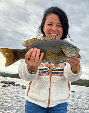 Happy guest holding nice smallmouth bass.